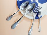 a plate with spoons and a fork on it