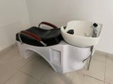 a white sink and a black and white chair in a bathroom