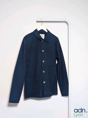the jacket is hanging on a hanger in the corner of the room