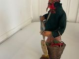 a figurine of a man with a basket of flowers