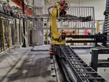 un robot qui travaille sur un tapis roulant dans une usine