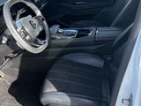 the interior of a car with the door open and the driver ' s seat down