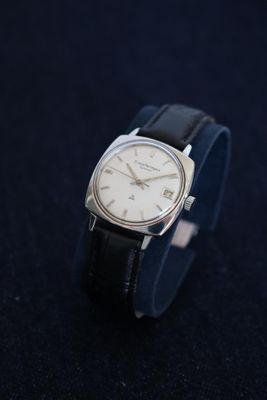 a close up of a wrist watch on a black surface