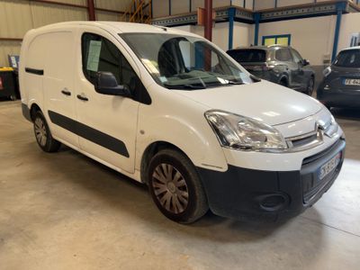 une camionnette blanche garée dans un garage, avec d'autres voitures en arrière-plan