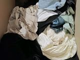 a box full of clothes that is sitting on the floor