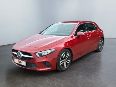 une Mercedes CLA rouge garée dans une pièce blanche