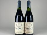 two bottles of wine sitting next to each other on a table