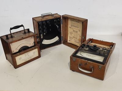 trois vieilles valises sont posées les unes à côté des autres sur une surface blanche