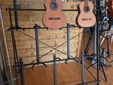 many guitars on display in a room with wood flooring