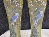two vases with peacocks painted on them sitting on a table