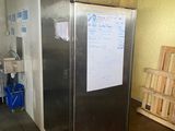 une photo d'un réfrigérateur dans une cuisine, avec un tableau blanc sur la porte