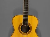 un gros plan d'une guitare acoustique sur fond gris