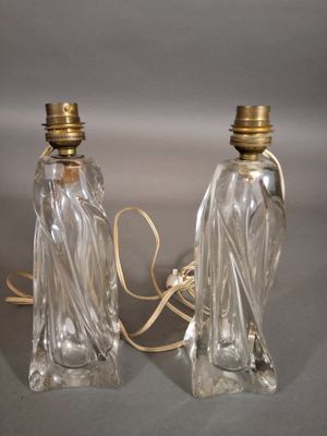 two clear glass lamps with gold trims on a gray surface
