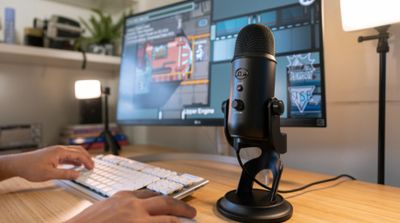 une personne assise à un bureau, avec un micro et un clavier