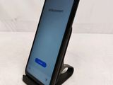 a close up of a cell phone on a stand on a white surface