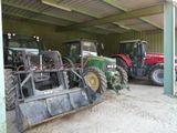 de nombreux tracteurs garés en rangée dans un garage