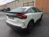 the rear end of a white car parked in a parking lot