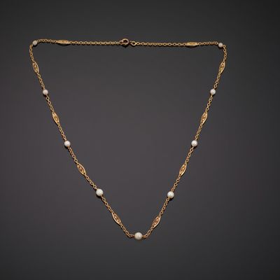 a gold necklace with pearls on a chain