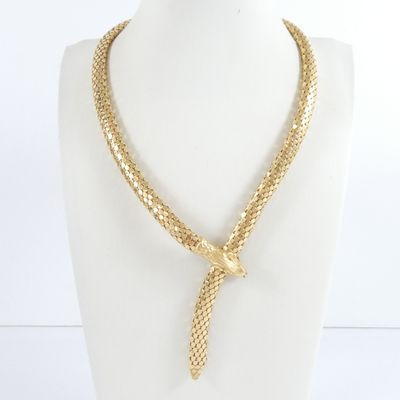 the necklace is made of gold colored metal and has a knot on it
