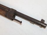 an old gun is laying on a white surface with a wooden handle