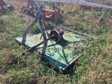 un tracteur qui est garé dans l'herbe près d'une clôture
