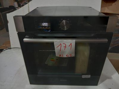 un four noir posé sur une table, avec une étiquette de prix dessus