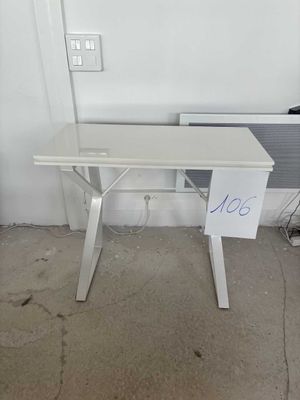 un bureau blanc sur lequel est posé un panneau, dans une pièce