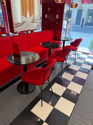 des tables et des chaises dans un restaurant aux murs rouges et au sol à carreaux