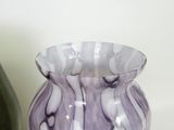 two vases that are sitting on a shelf next to each other