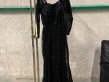 une photo d'une robe noire suspendue à un portant