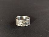 a close up of a silver ring on a black surface