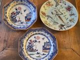 three plates with different designs on them sitting on a wooden table