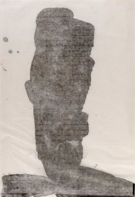photographie en noir et blanc d'une statue composée de pierres posée sur une table