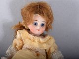 a close up of a doll with a yellow dress