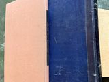 an old book sitting on top of a wooden table next to a book