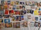 a lot of postcards on a bed with a white comforter