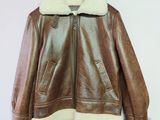 veste en cuir marron avec col et poignets en fourrure blanche, suspendue à un cintre