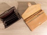 two wallets sitting on top of a wooden table next to each other