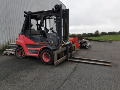 a red forklift parked in front of a building
