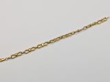 a gold plated bracelet with a chain that has been set on a white surface