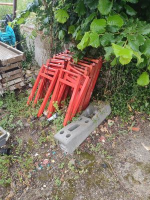 une pile de chaises rouges posées dans l'herbe
