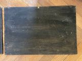 an old black book sitting on top of a wooden floor