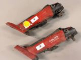 two red tools are sitting on a white surface