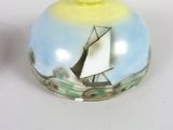 a small glass container with a sailboat painted on it