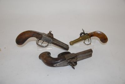two old revolvers sitting on a white surface with one being used as a gun