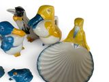 three figurines of birds that are sitting next to each other