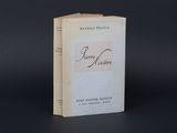 un vieux livre posé sur une table à côté d'un fond noir