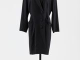 un manteau noir posé sur un mannequin, devant un fond blanc