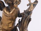 a statue of a little boy with a bird on a branch