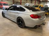 the rear end of a silver bmw car in a garage